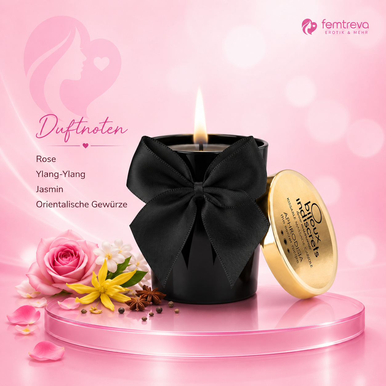 Massagekerze mit schwarzem Behälter, schwarzer Schleife und goldenem Deckel auf rosa Podest, Duftnoten Rose, Ylang-Ylang, Jasmin und orientalische Gewürze